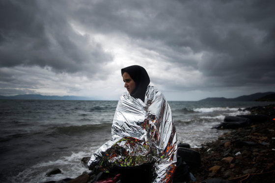 Image: A woman tries to warm up herself using a thermal blanket