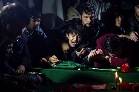 Image: Men mourn over the coffins