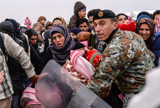 Image: A Macedonian soldier tries to controls refugees at the border on Nov. 20.