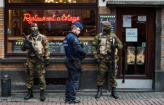 Image: A Police officer and soldiers stand guard in the 'Rue des Bouchers' street