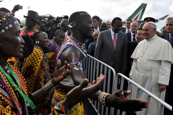 Image: Pope Francis stands beside Kenya's President Uhuru Kenyatta as they watch traditional dancers