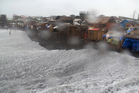 Image: Residents are seen in a coastal area battered by strong winds and heavy rains brought by typhoon Melor in Legazpi city, central Philippines