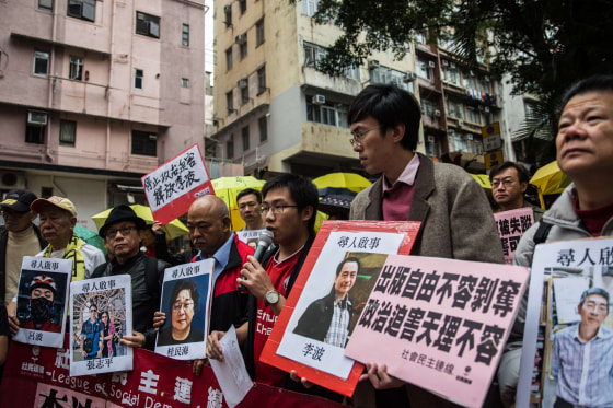 Image: Protesters hold up missing person notices