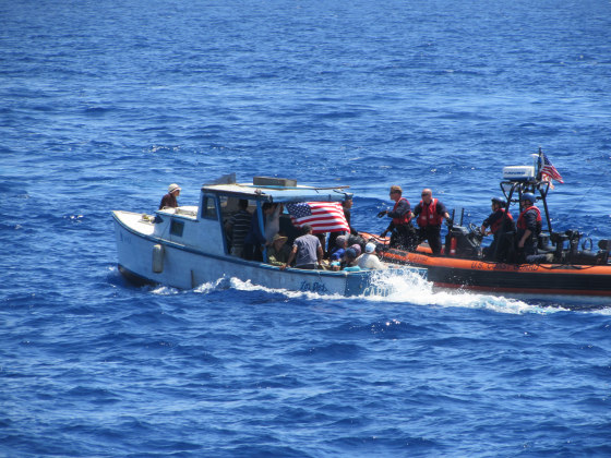 A Coast Guard boatcrew pulls alongside a vessel carrying Cuban migrants off the coast of Florida. The migrants were safely removed from the rustic vessel and repatriated to Cuba.