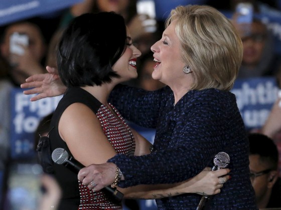 Image: U.S. Democratic presidential candidate Hillary Clinton is greeted by singer Demi Lovato as she arrives at a campaign event in Iowa City