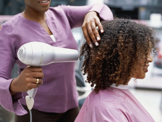 A woman has her hair dried at a salon.
