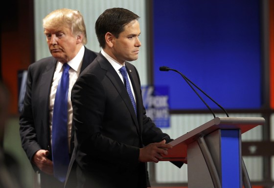 Image: Republican U.S. presidential candidate Trump walks behind rival candidate Rubio during a commercial break at the U.S. Republican presidential candidates debate in Detroit