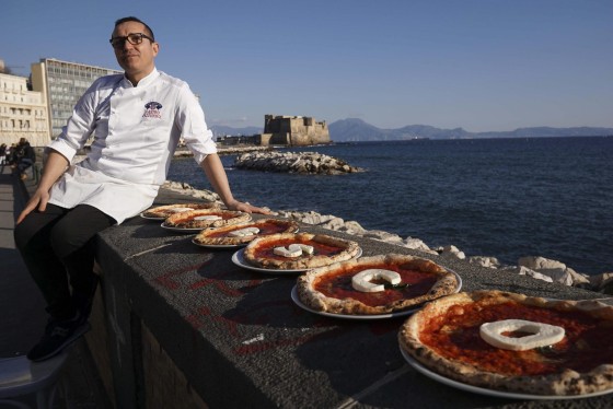 Image: Italian chef Gino Sorbillo shows his pizza with the words "UNESCO"