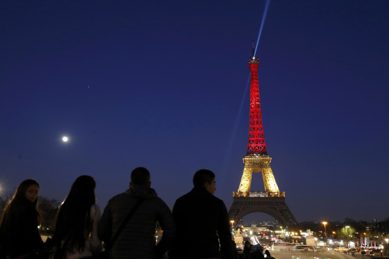 Image: The Eiffel Tower is seen with the black, yellow and red colours of the Belgian flag in tribute to the victims of today's Brussels bomb attacks in Paris