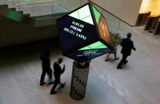 People walk through the lobby of the London Stock Exchange in London