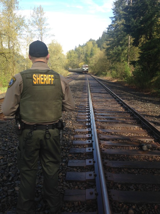 A deputy looks at evidence after two people were struck by a train in Oregon.