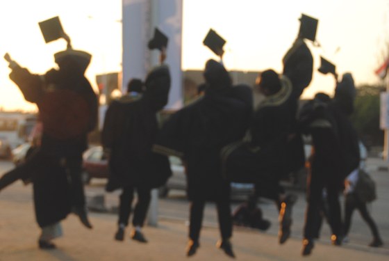 Rear View Of Excited Students Throwing Mortarboard During Graduation