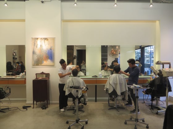 Stylists at Kakaboka in New York City work on clients as Seunghyun Suh, co-owner of the salon, greets customers.