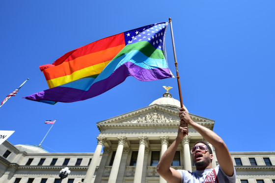 Meridian resident Nykolas Alford waves a rainbow-colored flag designed with the U.S. flag during a Human Rights Campaign protest of House Bill 1523 on the Mississippi State Capitol steps in Jackson, Miss., on March 29.