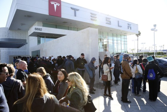 Image: Car buyers wait in line at the Tesla dealer