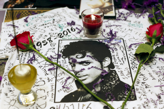Image: Flowers and candles are placed at a makeshift memorial for the music legend in Harlem, New York