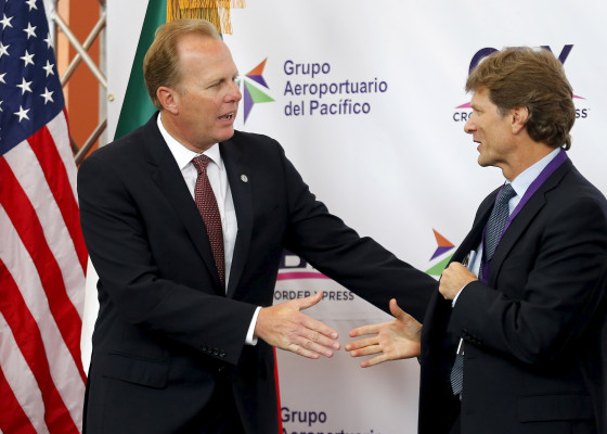 Image: San Diego Mayor Faulconer shakes hands with Mexico's Secretary of Tourism de la Madrid Cordero during the official opening of a privately funded cross border pedestrian bridge that connects the United States with Tijuana International Airport, in O