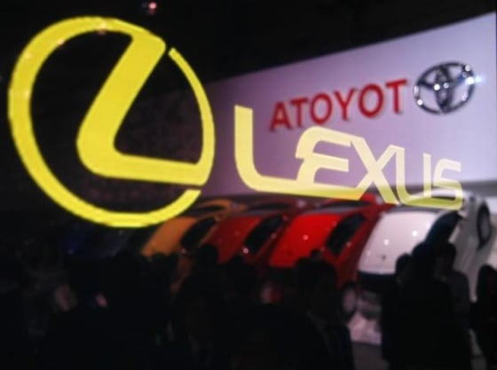 A Lexus logo on glass reflects a Toyota Motor Corp logo at the 41st Tokyo Motor Show in Chiba, east of Tokyo