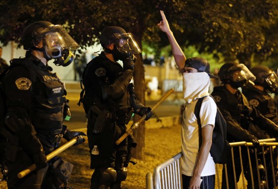 Image: Riot police face off with a protester in Albuquerque