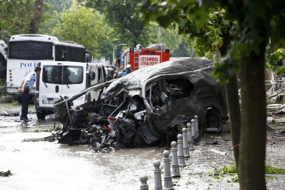 Image: A destroyed van is near a Turkish police bus which was targeted in a bomb attack