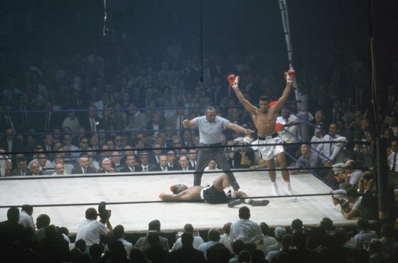 Muhammad Ali raises his arms in celebrations after putting down Sonny Liston in the canvas as referee Jersey Joe Walcott gives count in the first round of the World Heavyweight Title bout at St. Dominic's Hall on May 25, 1965 in Lewiston, Maine.