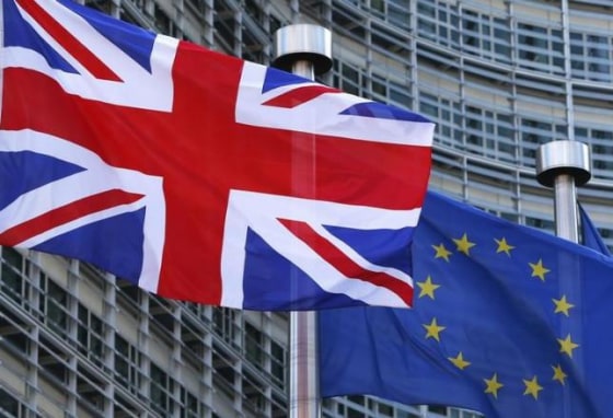 A Union Jack flag flutters next to European Union flags ahead of a visit from Britain's PM Cameron at the EU Commission headquarters in Brussels
