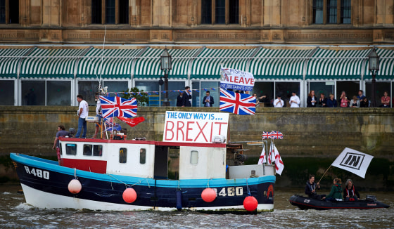 Image: A boat decorated with flags and banners from the 'Fishing for Leave' group