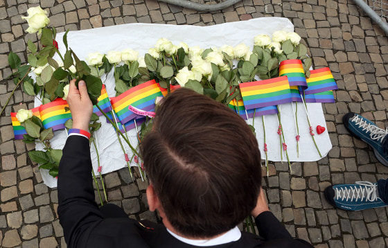 A visitor places flowers at a makeshift memorial during a vigil for victims of a shooting at a gay nightclub in Orlando, Florida the previous day, in front of the United States embassy on June 13, 2016 in Berlin, Germany.