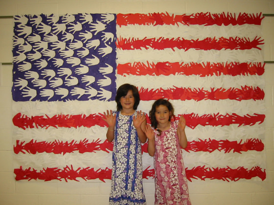 Frances Kai-Hwa Wang's daughters, M and Hao Hao, with an American flag made out of the handprints of all their schoolmates.