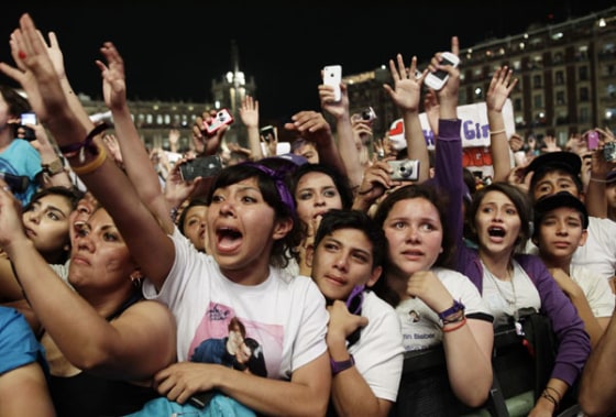 Fans of Canadian pop singer Justin Bieber react as he performs at a free open-air concert at Zocalo Square in Mexico City
