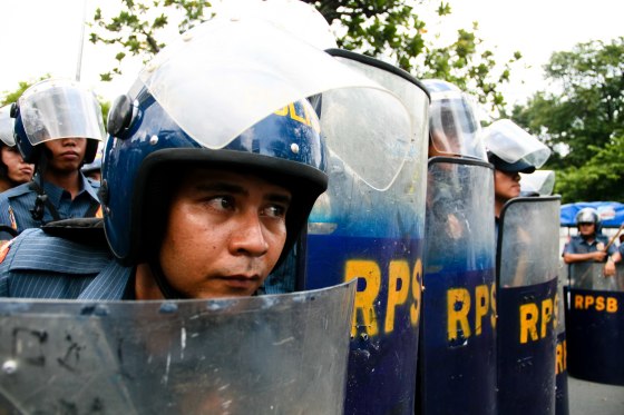 A police officer prepares his shield for the approaching