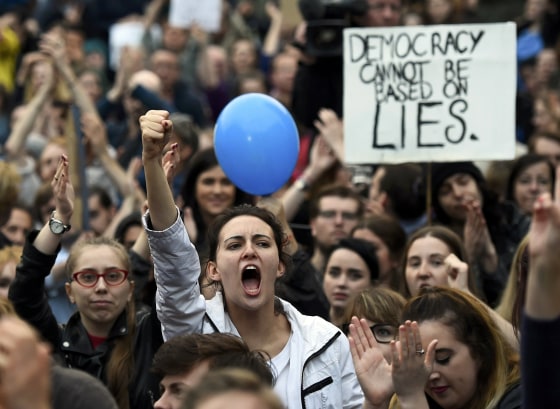 Image: Demonstrators gesture outside the Houses of Parliament