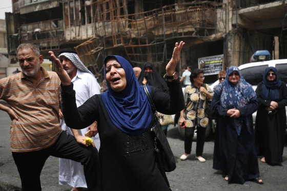 Image: Iraqis react at the site of a suicide-bombing attack