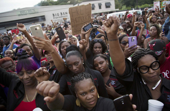 Image: Community members attend a vigil in memory of Alton Sterling, who was shot dead by police, at the Triple S Food Mart in Baton Rouge