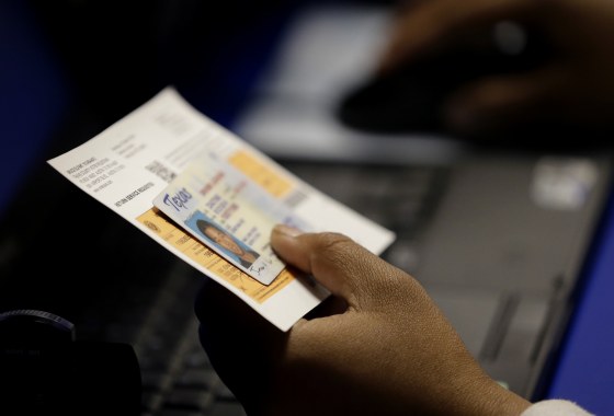 An election official checks a voter's photo identification at an early voting polling site in Austin, Texas on Feb. 26, 2014. A federal appeals court ruled Wednesday, July 20, 2016, that Texas' strict voter ID law discriminates against minorities and the poor and must quickly be scrubbed of those effects before the November 2016 election. Voters will still need to show identification at the polls under the decision by the New Orleans-based 5th U.S. Circuit Court of Appeals, according to attorneys who challenged the law, but a lower court will now also have to devise a way for Texas to accommodate those who cannot.