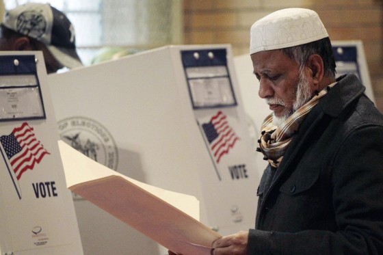 Kamal Pasha, originally from Bangladesh, reads over his ballot at a polling station in the Kensington neighborhood of Brooklyn on Nov. 5, 2013.