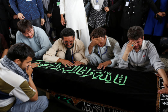 Image: Men mourn over the coffin of a victim a day after a suicide attack in Kabul, Afghanistan