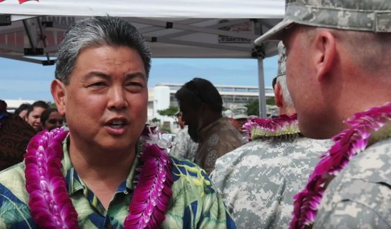 This screenshot from a tribute video for Rep. Mark Takai shows the light congressman speaking with service members.