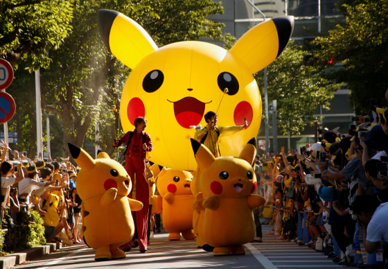 Image: Performers wearing Pokemon's character Pikachu take part in a parade in Yokohama