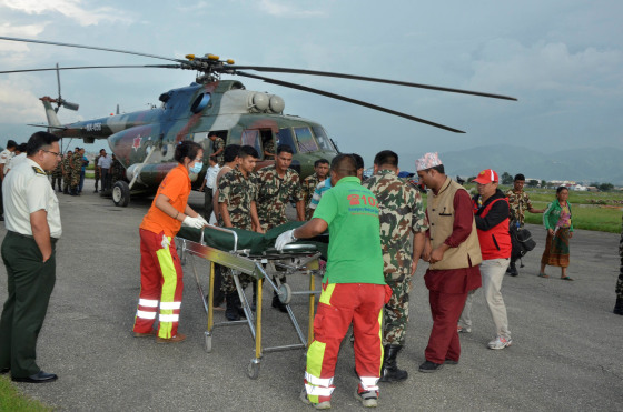Image: Nepalese army personnel assist a victim of a bus accident