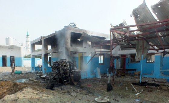 Image: A dead body is seen at the site of a Saudi-led air strike on a hospital in Abs district