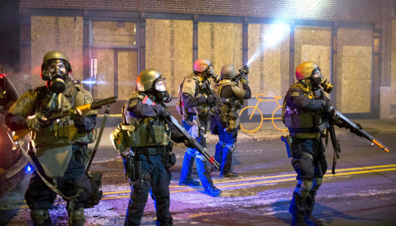 Image: Police officers react to violent protesters during a second night of protests in Ferguson, Missouri