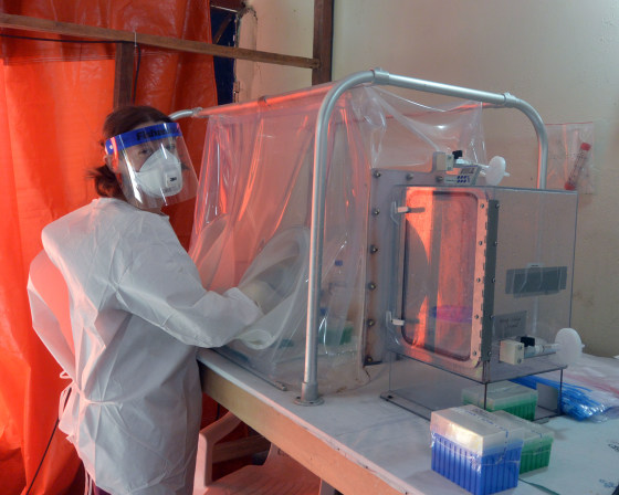 Emmie de Wit of the National Institute of Allergy and Infectious Diseases at the diagnostic laboratory in Monrovia, Liberia, using a sealed glovebox to deactivate virus in patient blood samples before testing for Ebola.