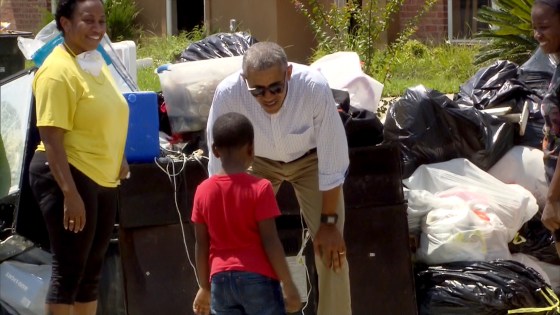 President Barack Obama meets a young resident of Louisiana as he tours flood damage.
