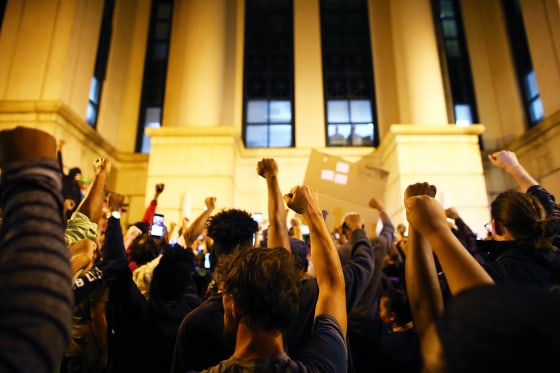 Image: Protesters hold a moment of silence at the police station for a protester that died during protests September 21 during another night of protests over the police shooting of Keith Scott in Charlotte