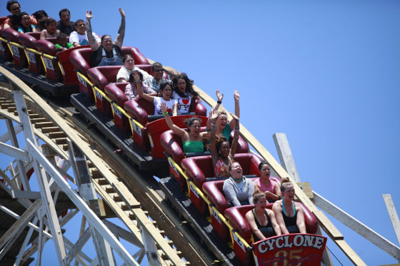 Image: People ride the Cyclone roller coaster at Coney Island in the Brooklyn borough of New York
