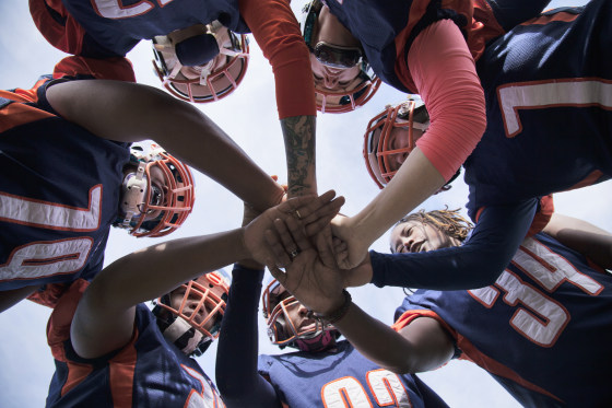 Female professional football players in huddle