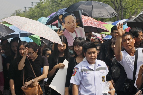 Mourners gather to pay their respects to the late Thai King Bhumibol Adulyadej, in portrait center, outside the Grand Palace in Bangkok, Thailand, Sunday, Oct. 16, 2016.