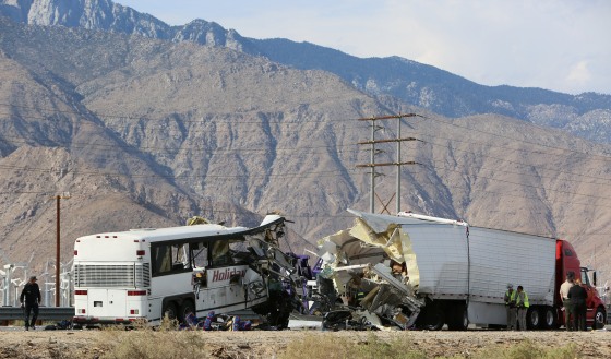 Image: Investigators confer at the scene of a mass casualty bus crash on the westbound Interstate 10 freeway near Palm Springs, California