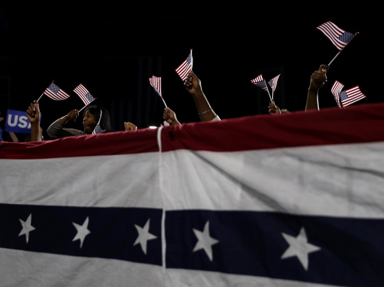 Image: Supporters hold American flags at a rally for Hillary Clinton